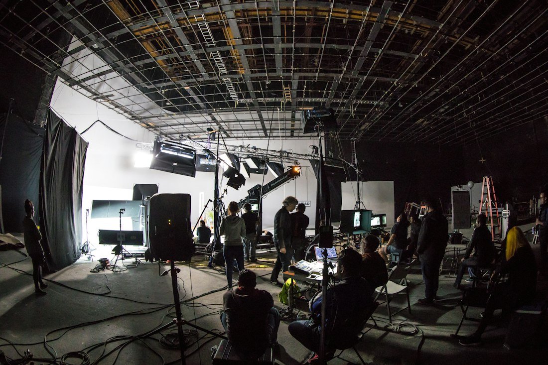 Equipe de filmagem trabalhando em estúdio com luz e câmeras