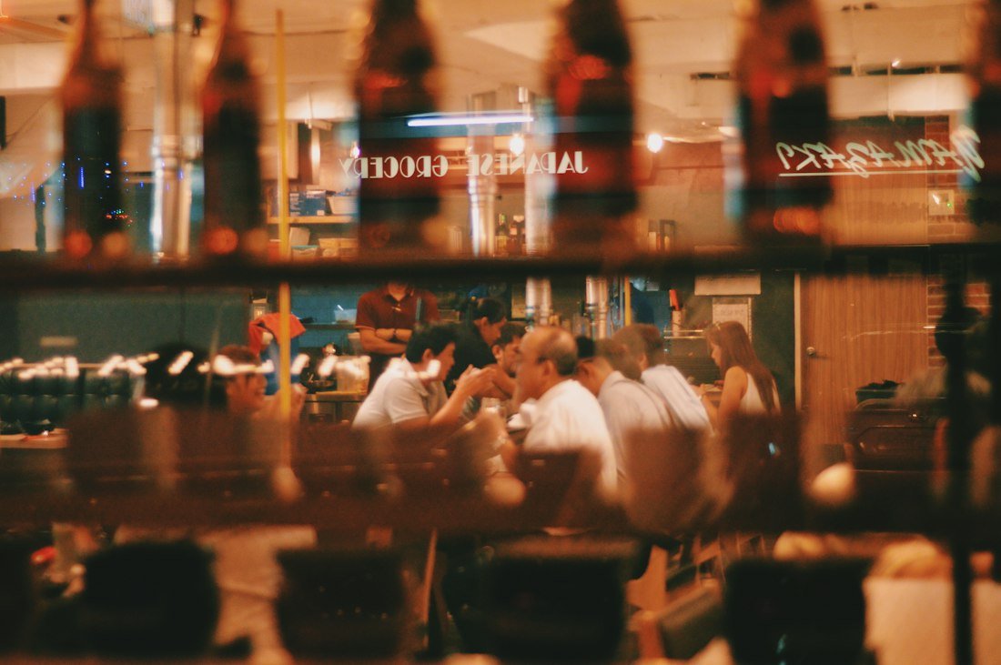 Salão de restaurante com mesas ocupadas e luz quente